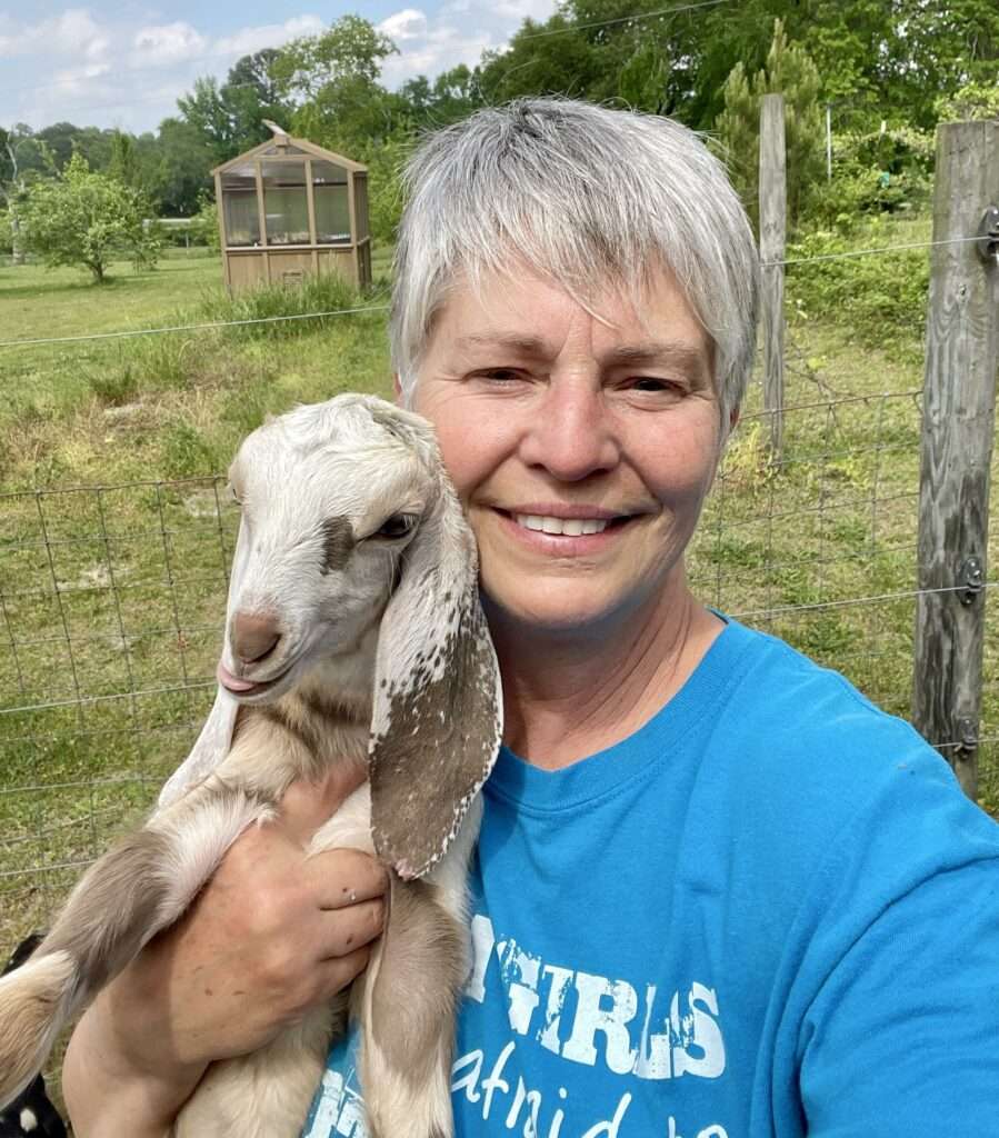 Woman holding a Nubian dairy goat kid (Evelyn and Honey)