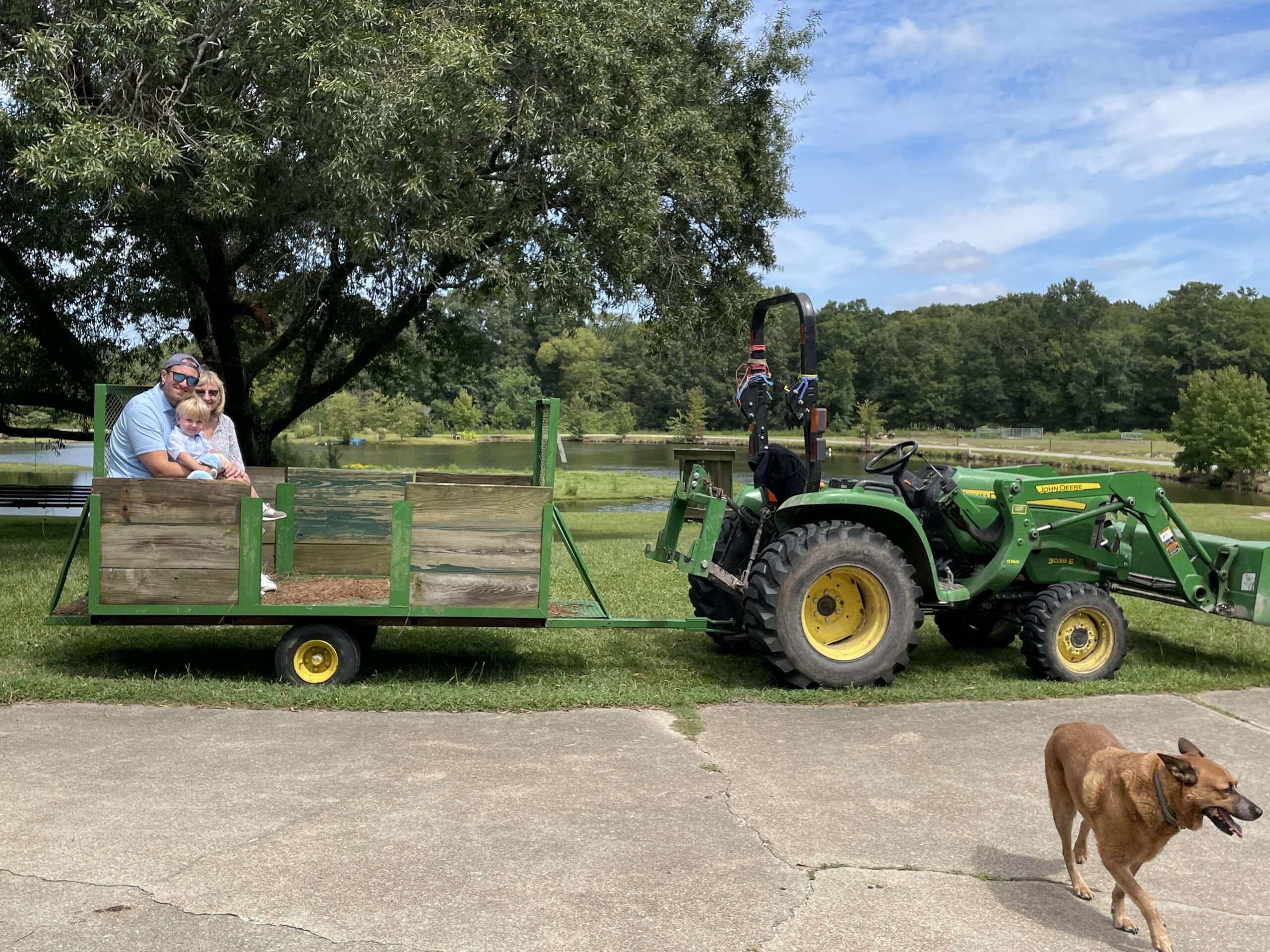 Woman, man, and child on tobacco trailer for tractor ride on the farm.